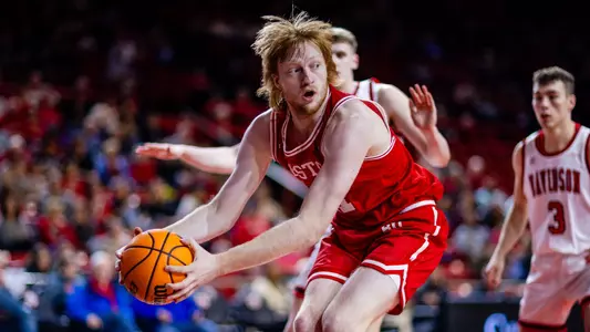 Otto Landrum holds the ball low while surrounded by Davidson defenders in the paint.