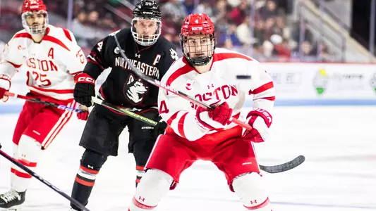 Ty Gallagher skating in front of a Northeastern player