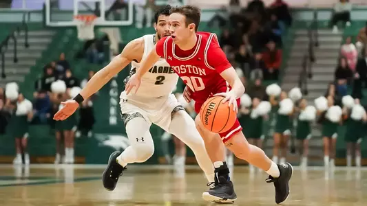 Ben Roy dribbles toward the hoop while guarded by a Wagner defender