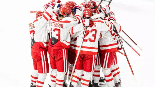Men's ice hockey players celebrating Jeremy Wilmer's overtime goal against Northeastern