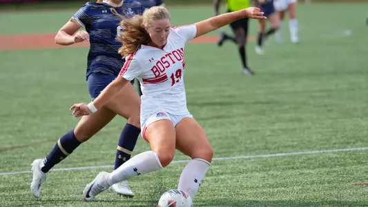 Photo of women's soccer sophomore Ava Maguire passing the ball at Nickerson Field.