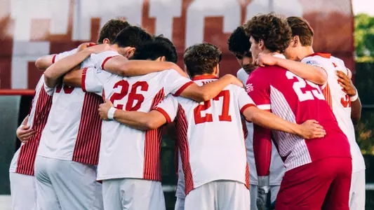 BU men's soccer starters huddle up before the start of a game.