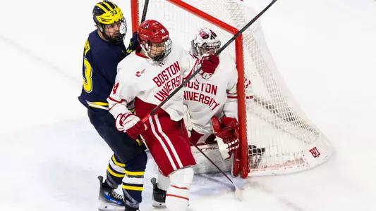 Mick Frechette battles with a Michigan player in front of Mathieu Caron