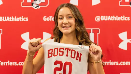 Photo of BU women's basketball recruit Kate Allard posing in a white BU uniform.