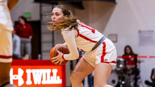 Photo of women's basketball sophomore Bella McLaughlin holding the ball at midcourt in a game at Case Gym.