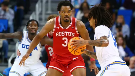 Malcolm Chimezie is defending a UCLA player at the top of the key