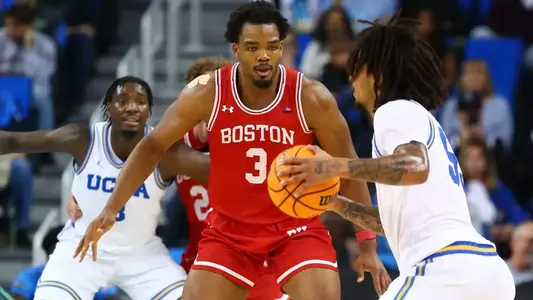 Malcolm Chimezie is defending a UCLA player at the top of the key