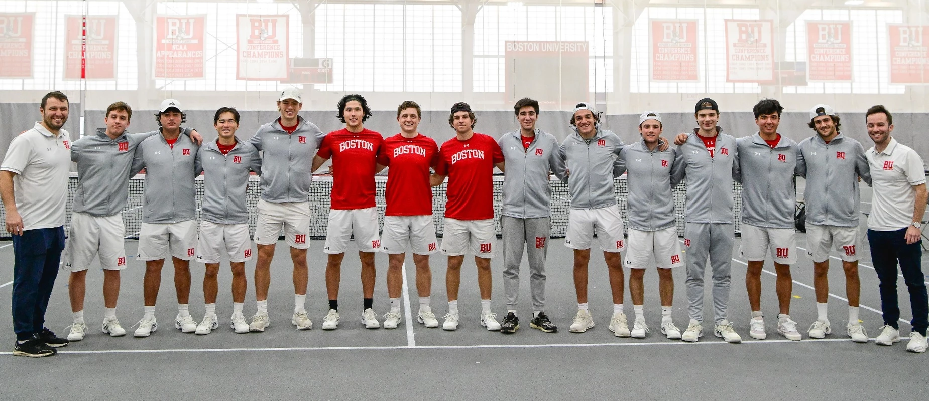 2023-24 BU Men's Tennis Team line up for a group photo at the Track & Tennis Center