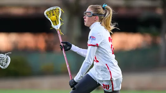 Reilly Walsh runs with the ball on the lacrosse field