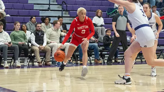 Photo of women's basketball senior Kelsi Mingo dribbling baseline against Holy Cross.