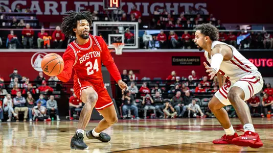 Miles Brewster is in the beginning of a passing motion toward a teammate in the paint at Rutgers.