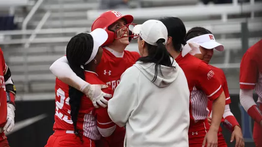 Caitlin Coker is hugged by teammates after hitting a homer against Michigan State