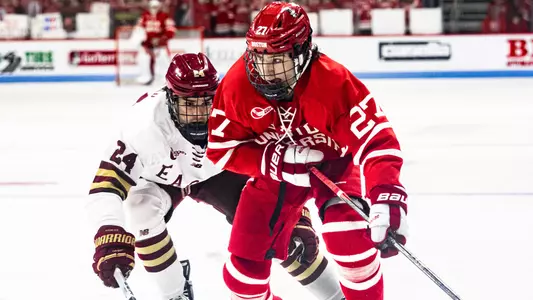 Jack Hughes skating past a BC player