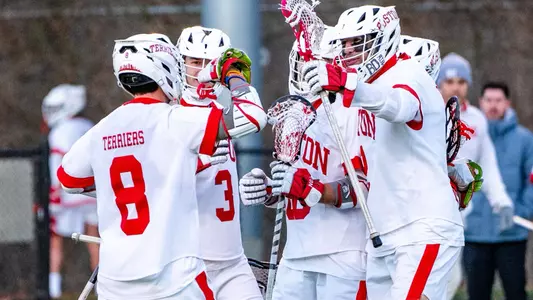 Men's lacrosse players celebrating a goal against Saint Joseph's
