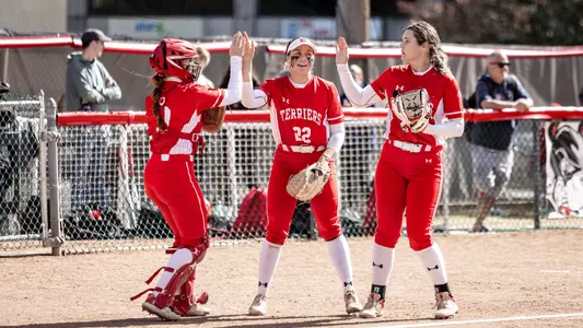 Caitlin Coker, Livia Christopher and Lizzy Avery greet one another coming off the diamond with high fives.