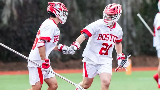 Dane DeGoler and Charlie Huntley fist bump as they run off Nickerson Field after a play