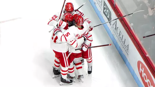 Men's ice hockey players celebrating a goal against Northeastern