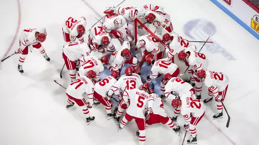 Men's Hockey players huddle with their goalie before a home game