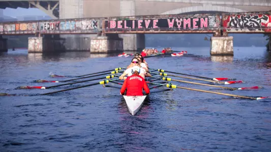 Photo of the Women's Rowing team rowing near the BU Bridge during practice.