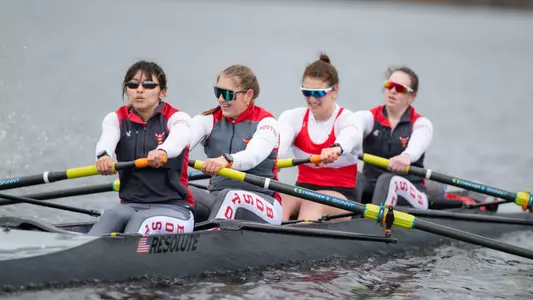 Photo of the BU Women's Rowing four racing on the Charles River.