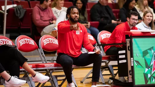 Photo of women's basketball assistant coach Jason Pellum giving directions from BU's bench.
