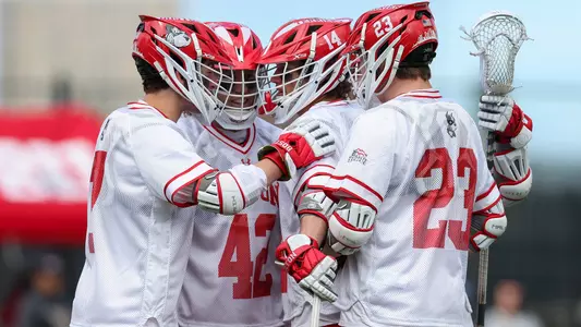 Men's lacrosse players celebrating a goal