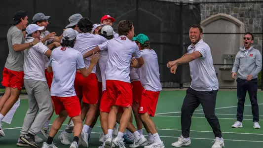 Men's Tennis team jumps into a dogpile celebrating a Patriot League championship