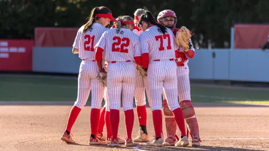 Kasey Ricard and the infielders huddle in the circle before the start of an inning