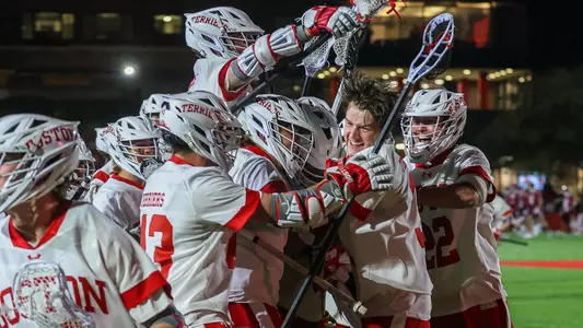Men's lacrosse players celebrate Brenden Kelly's game-winning goal against Colgate