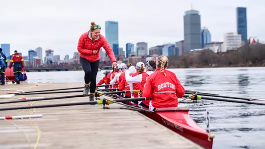 Photo of Lightweight Rowing Head Coach Mary Foster fist-bumping the Terriers before launching.