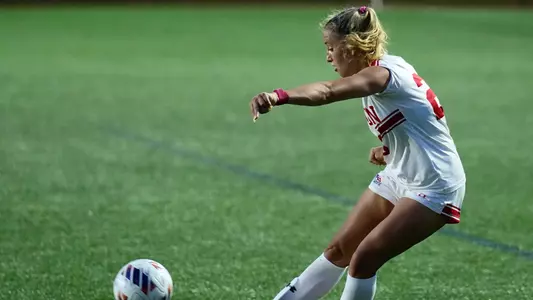 Photo of BU women's soccer senior Morgan Fagan crossing a ball in a game at Nickerson Field.