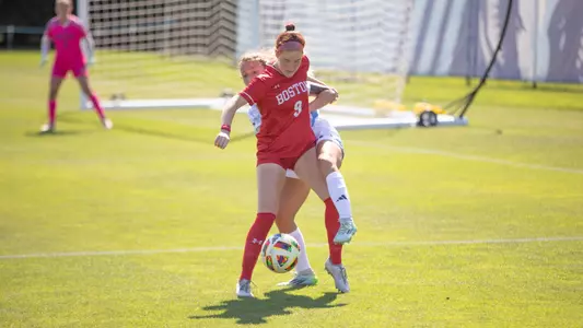 Photo of women's soccer junior Margy Porta gaining possession against a URI defender.