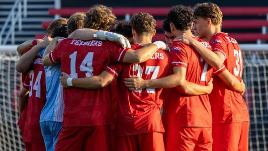 BU men's soccer starters huddle at Northeastern