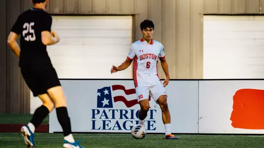 Junior Diego Rived is dribbling the ball looking to make a pass along the sideline
