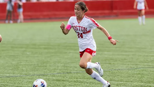 Photo of women's soccer graduate student Lily Matthews dribbling the ball on Nickerson Field.