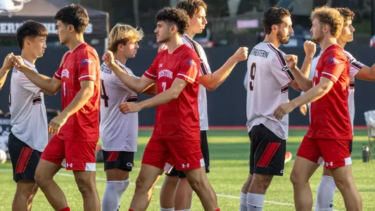 BU men's soccer starters fist bump with the Northeastern starters before the beginning of the game.