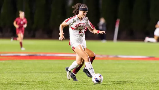 Photo of women's soccer junior Helene Tyburczy dribbling the ball against Harvard.
