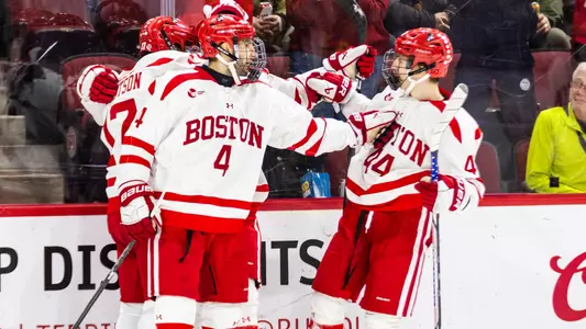 Men's ice hockey players celebrate a goal