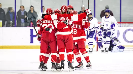 Women's ice hockey players celebrate a goal at Holy Cross