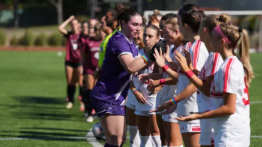 Photo of BU women's soccer goalkeeper Bridget Carr high-fiving her teammates.