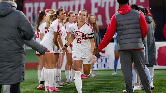 Photo of BU women's soccer senior Giulianna Gianino high-fiving her coaches.