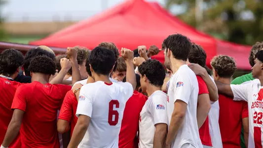 men's soccer team huddles together before the start of a game.