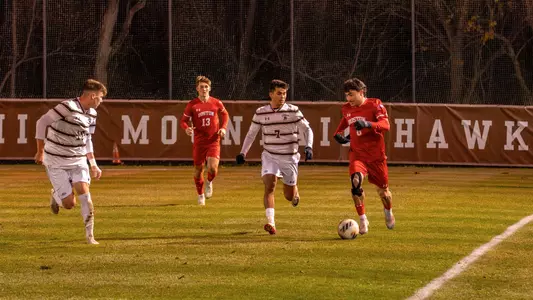 Boston University men's soccer dribbles the ball up the field with Lehigh defender on the side