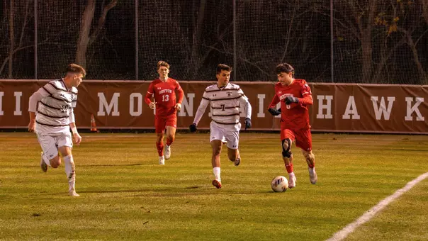Boston University men's soccer dribbles the ball up the field with Lehigh defender on the side