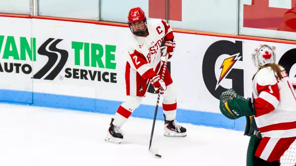 Maeve Carey skates with the puck behind the net at home