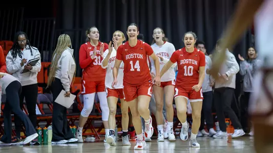 Photo of BU Women's Basketball guards Inés Monteagudo (center) and Rose Azmoudeh (right) celebrating at Northeastern.