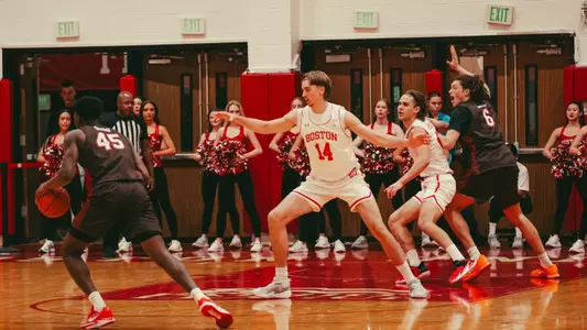 Men's basketball team on the court is in a defensive set with Brown passes the ball around the top of the arc.