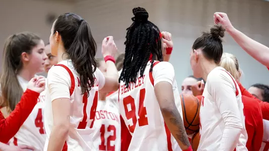 Photo of the BU Women's Basketball team huddling at Case Gym.
