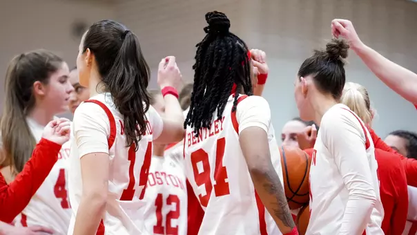 Photo of the BU Women's Basketball team huddling at Case Gym.