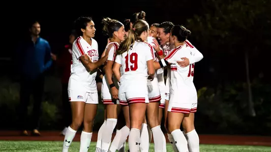 Photo of the BU Women's Soccer team celebrating a goal at Nickerson Field.